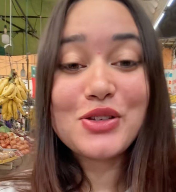 Joven cubana emocionada al encontrar productos típicos de Cuba, como malta y café Serrano, en el mercado Medellín de Ciudad de México.