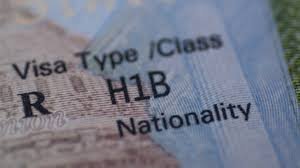 Profesional extranjero sonriendo con documentos de la Visa H-1B EEUU en mano, listo para trabajar en Estados Unidos.