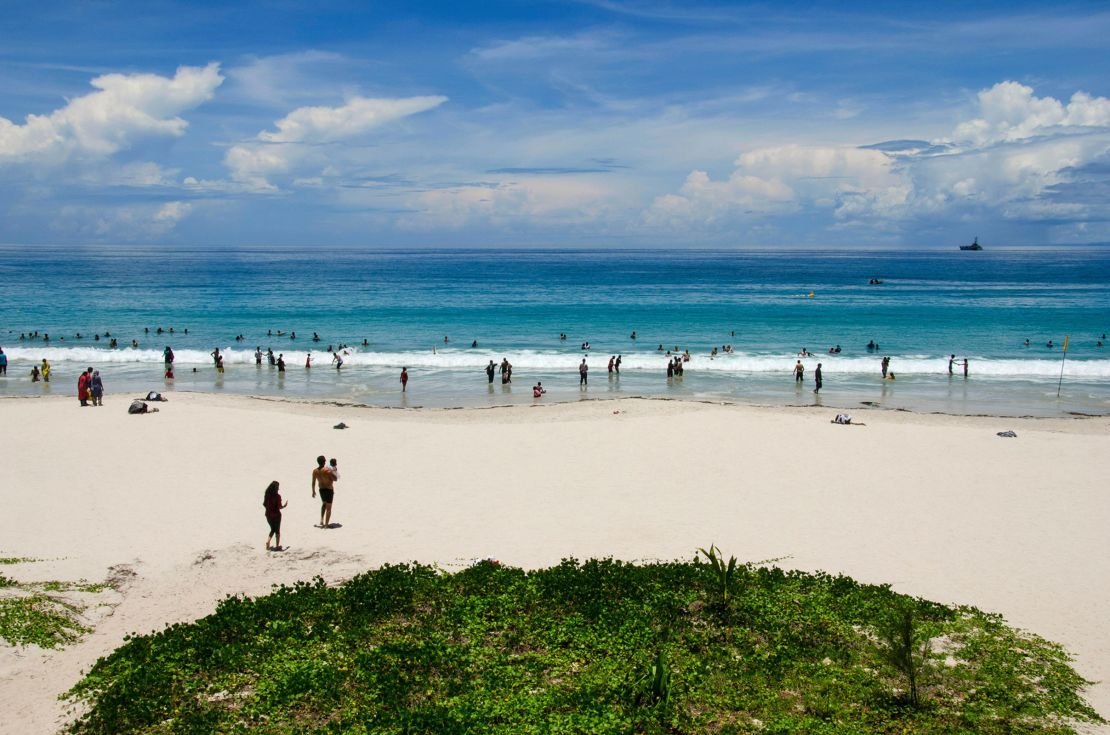 Turistas disfrutando de una playa en el Caribe, uno de los destinos favoritos de los viajeros de Estados Unidos, mientras Cuba queda fuera de la lista.