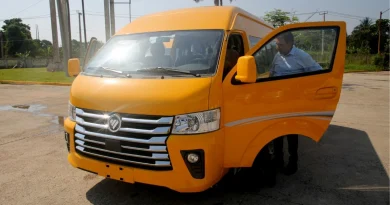 Varios microbuses blancos nuevos estacionados en fila en una calle de Cuba, representando la nueva flota para el transporte público.