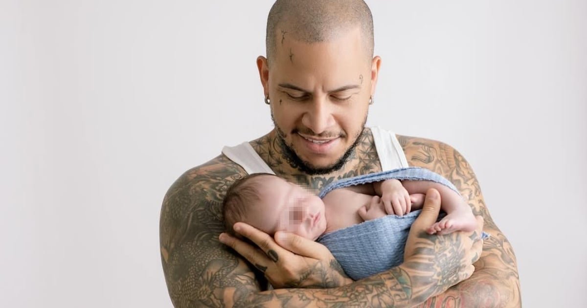 El reguetonero cubano El Chulo sostiene con ternura a su bebé Justin, sonriendo, en una emotiva imagen que resalta su faceta paternal.