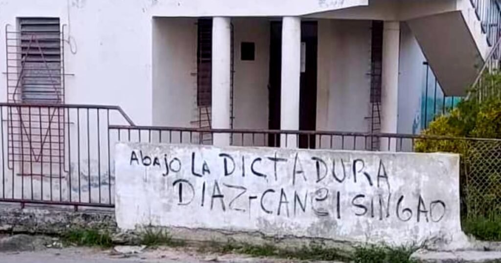 Grafiti con la frase 'Abajo la dictadura. Díaz-Canel singao' en la pared de un consultorio médico en La Hata, Guanabacoa, La Habana.