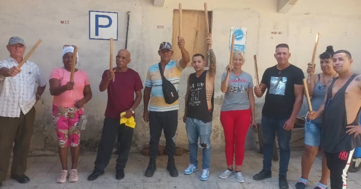 Civiles cubanos participan en ejercicios del Día de la Defensa con grandes palos de madera, cuestionando el poderío militar cubano.