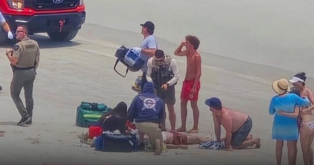Socorristas asisten a víctima luego de que un joven muere por un rayo en Florida en la playa de New Smyrna.