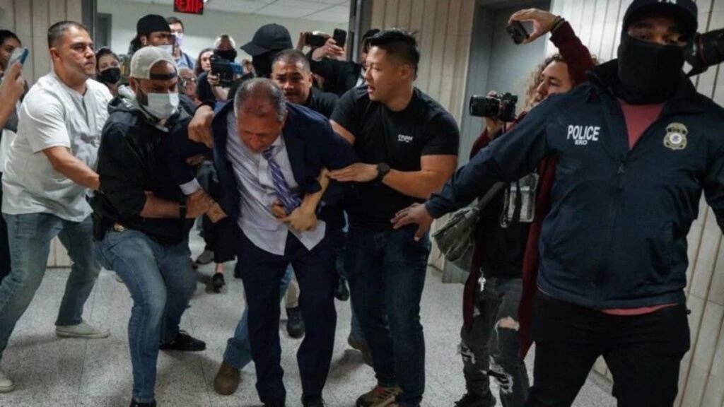 El contralor de Nueva York, Brad Lander, siendo detenido por agentes de ICE contra una pared en un tribunal.