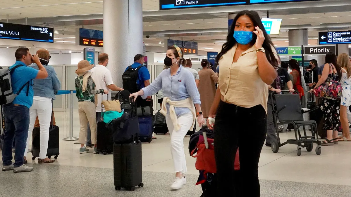 Pasajeros en una terminal concurrida del Aeropuerto Internacional de Miami durante el feriado del 4 de Julio.