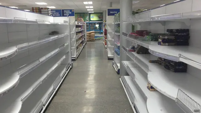 Estantes y neveras vacías en una tienda en dólares en Cuba, ilustrando la severa escasez de productos básicos que afecta a la isla.