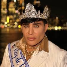 Eduardo Antonio sonriendo y ondeando la bandera cubana como Rey del Carnaval Cubano en Nueva York.