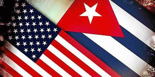 Banderas de Cuba y EE.UU. cruzadas, simbolizando el caso del represor cubano deportado desde Miami por violaciones a los derechos humanos.