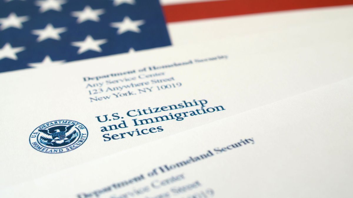 Formularios de inmigración de USCIS sobre un escritorio, simbolizando el aumento de las tarifas de trámites migratorios en EE.UU.
